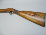 an old rifle with a wooden handle on a white surface