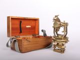 une petite boîte en bois contenant un objet en laiton