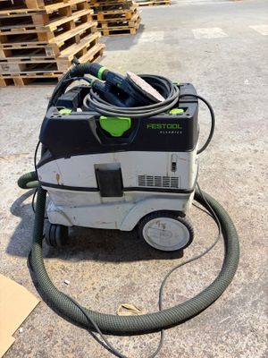 an image of a dust extracter sitting on the ground next to pallets