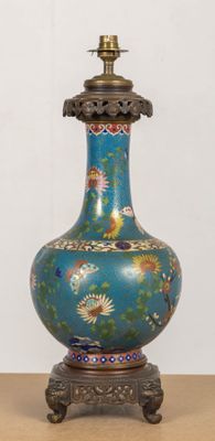 un vase bleu posé sur une table, avec une lampe posée dessus
