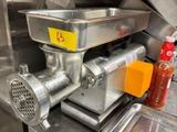 un hachoir à viande posé sur un plan de travail dans une cuisine