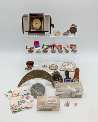 une vitrine sur laquelle sont disposés une horloge et divers objets