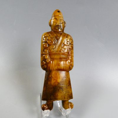 an old carved figurine of a man with a hat and coat