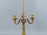 an antique brass candelab with three candles on a stand