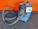 une machine bleue à laquelle est raccordé un tuyau