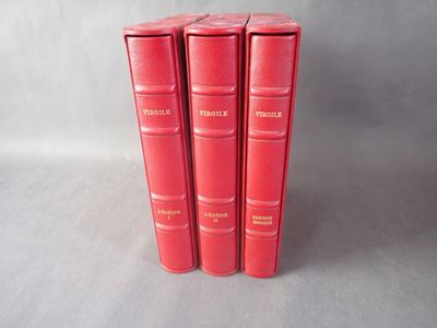 Trois livres rouges sont empilés les uns sur les autres sur une table