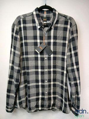 plaid shirt with a tie on a hanger in front of a white wall