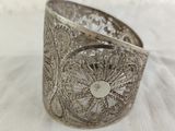 a close up of a silver bracelet on a white cloth