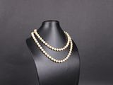 un collier de perles blanches sur un mannequin noir
