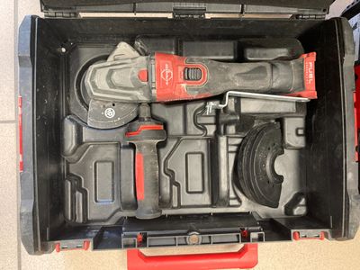une boîte à outils contenant des outils, posée sur le sol