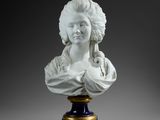 marble bust of a woman holding a bird on a pedestal