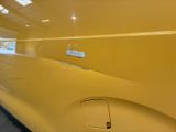 a close up of a yellow car with a sticker on it
