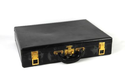 une valise noire avec des poignées dorées sur un fond blanc