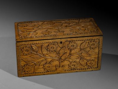 une vieille boîte en bois sculptée posée sur une table