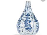 un vase bleu et blanc posé sur une surface blanche