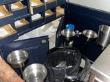 de nombreuses casseroles et poêles dans la cuisine, à côté d'une poubelle
