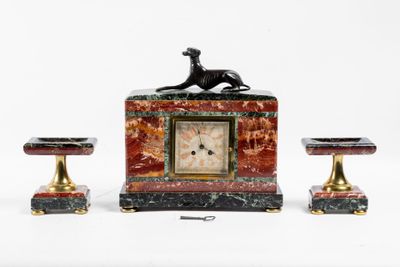 une horloge surmontée d'un chien, à côté de deux tabourets