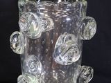a glass vase that has a bunch of flowers on it