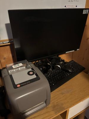 un ordinateur et une imprimante posés sur un bureau dans une pièce