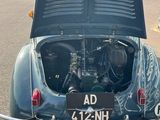 an old car with its hood open in a parking lot