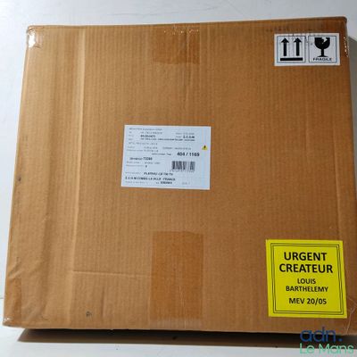 une boîte en carton sur laquelle est collé un autocollant, posée sur une table