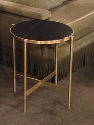 a black table with a gold base in a living room