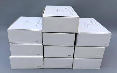 plusieurs boîtes blanches empilées les unes sur les autres sur une surface grise
