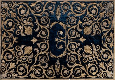 un gros plan d'un tapis bleu et or posé sur une surface blanche