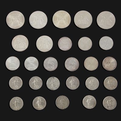 a group of twenty different british coins on a black background