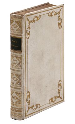 un vieux livre posé sur une table blanche à côté d'un mur blanc
