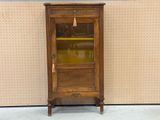 a wooden cabinet with a glass door and a clock on it