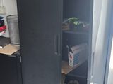 a black refrigerator in the corner of a kitchen