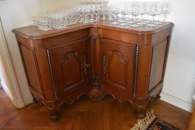 a corner cabinet with wine glasses on top of it
