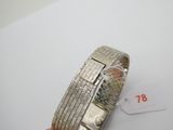 quelqu'un tient un bracelet en argent sur lequel figure un numéro