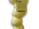une boîte aux lettres jaune fixée au mur, à laquelle sont accrochés plusieurs ballons