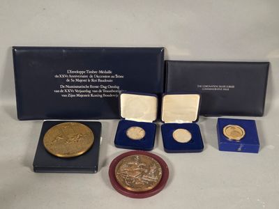 an assortment of gold and silver coins including a medal, a medal, and a medal
