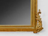 a gold framed mirror hanging on a white wall