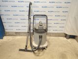 the vacuum is sitting on the floor next to the wall