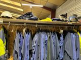 many jackets and hats hanging on a rack in a store