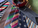 many ties laid out on a green table cloth
