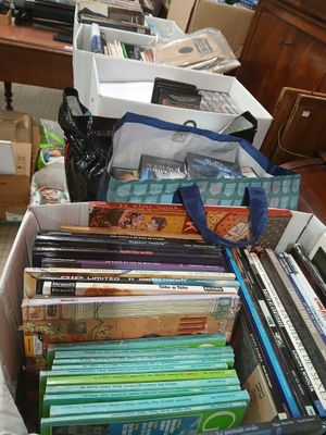 a box full of books sitting on the floor next to a desk