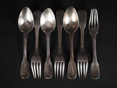 six cuillères et une fourchette sont alignées sur un fond noir