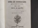an open book with a black and white image of a coat of arms on it