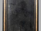 an image of a black and gold framed mirror