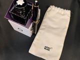 a pen and a bag on a table next to it