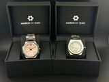 deux montres dans un coffret noir posé sur une surface noire