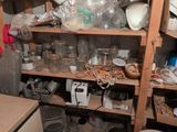 a wooden shelf filled with glass jars and other items
