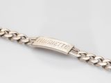 a close up of a silver bracelet on a white surface