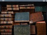 de nombreux livres anciens dans une boîte noire posée sur une table