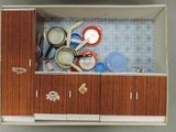 a doll house kitchen with a sink and cupboards